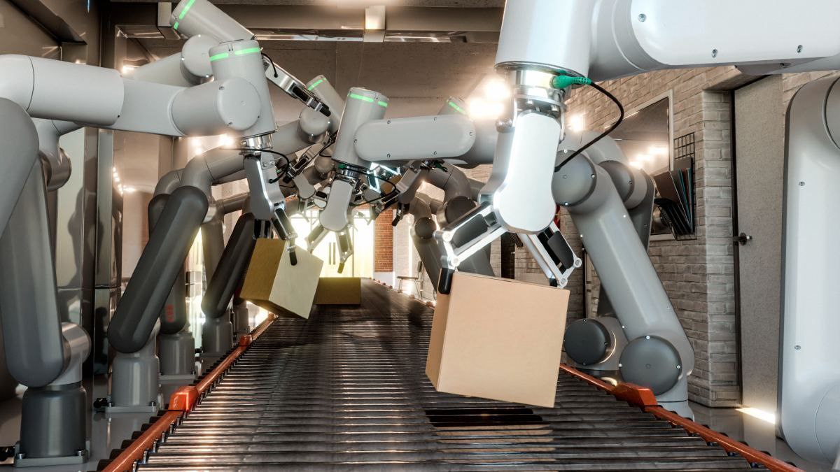 Brazos robóticos automatizados manipulan cajas sobre una cinta transportadora dentro de un entorno industrial moderno y bien iluminado.